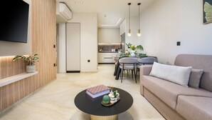 Un salon moderne comprenant un canapé, une table basse et un coin repas avec des chaises et une table.