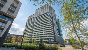 Een meerlaags gebouw met een modern architectonisch ontwerp, met een combinatie van balkons en grote ramen.