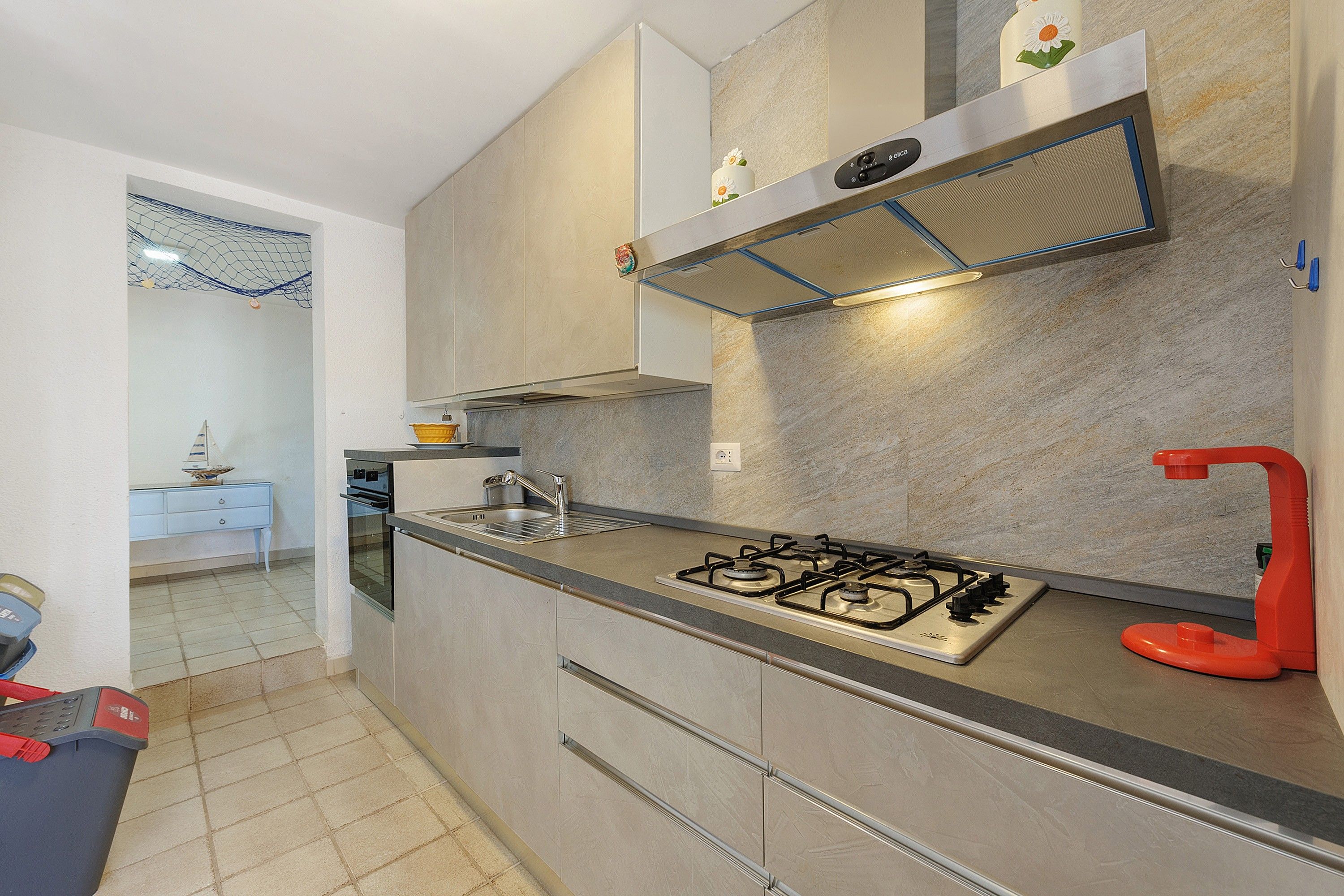A modern kitchen with a gas stove, stainless steel appliances, and a tiled backsplash.