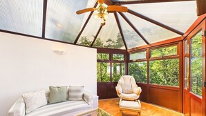 A room with a glass ceiling, a sofa, a chair, and a coffee table.