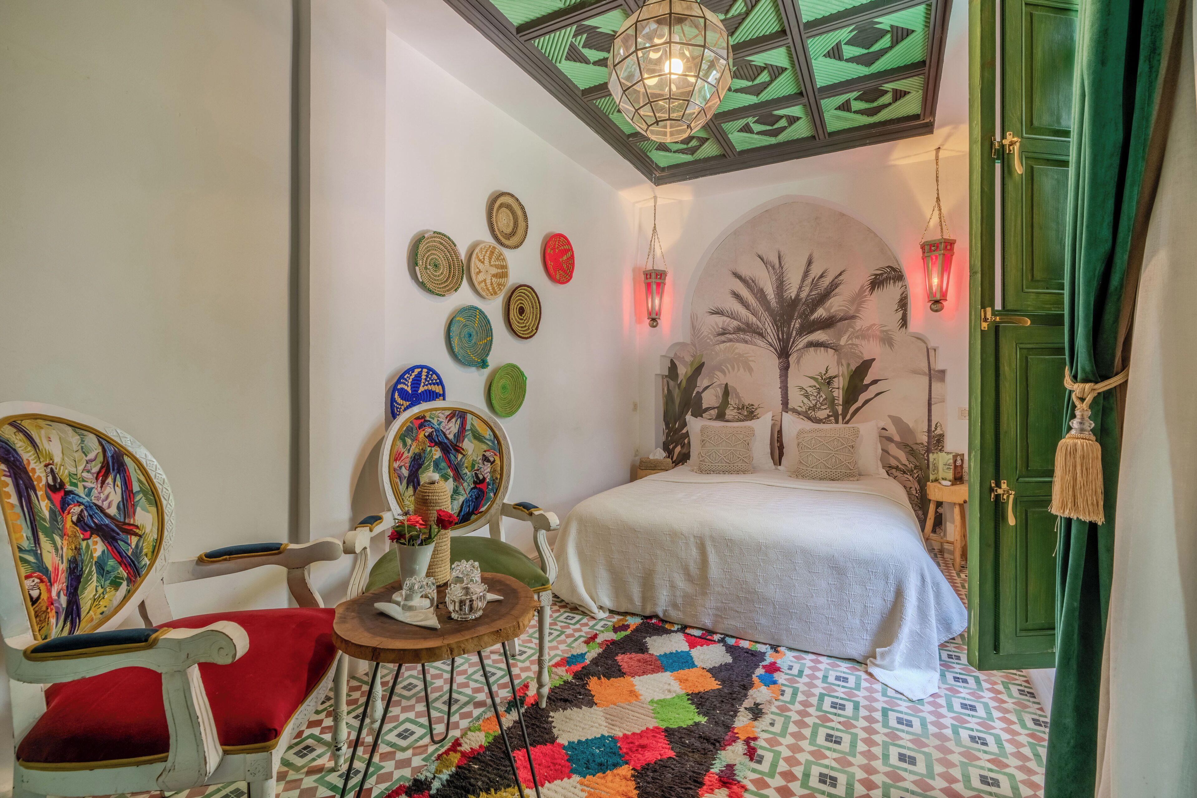 Un dormitorio con cama, una silla, una mesa y una pared decorada con placas.