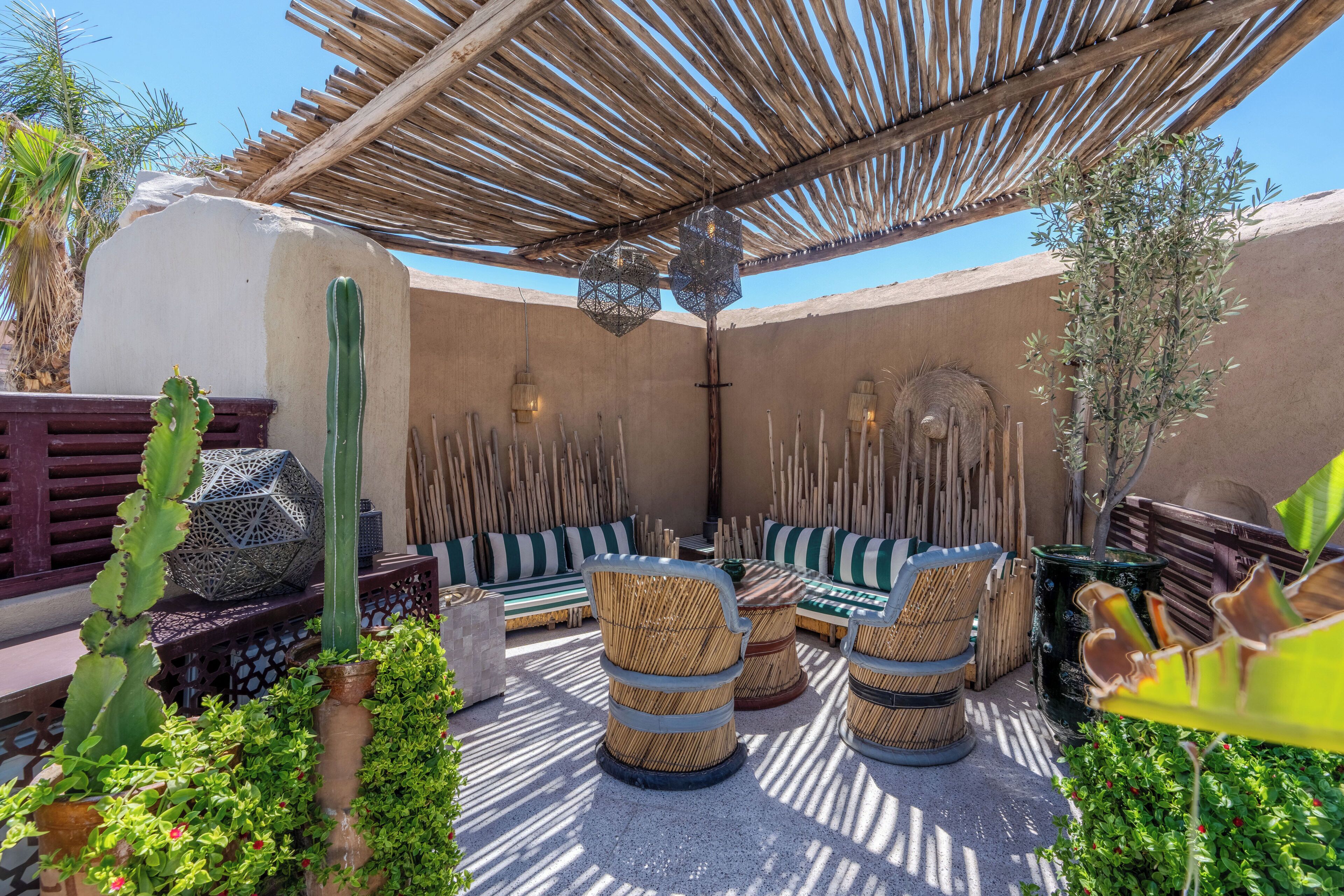 An outdoor seating area with woven chairs and a thatched roof.