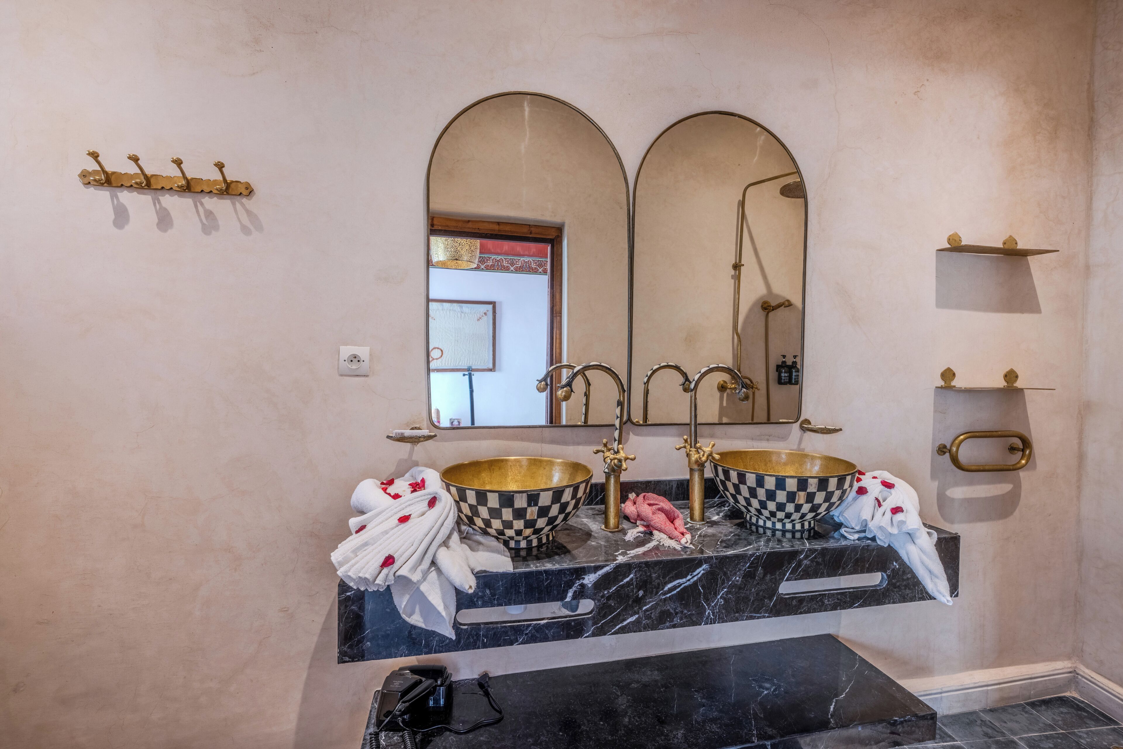 A bathroom with two sinks, a large mirror, and a shower.