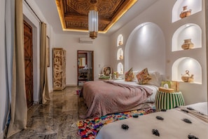 A room with a bed, a small table, a mirror, and a decorative ceiling. - Riad Jil & Spa Marrakech (Marrakech)