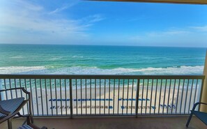 Ein Balkon mit Blick auf den Ozean und den Strand.