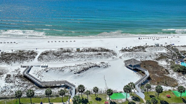 A beach resort with a large sandy area, a small water body, and a few structures including a building with a balcony. - Beachy 2BR Escape with Pool Views  | St. Martin Beachwalk Villa 314 (Destin)