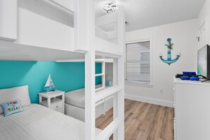 A room with bunk beds, a desk, and a window with blinds. - Beachy 2BR Escape with Pool Views  | St. Martin Beachwalk Villa 314 (Destin)