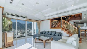Una sala de estar moderna con un sofá, una mesa de centro y una escalera con barandales ornamentales.