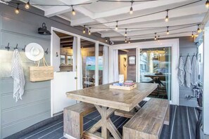 Ein Essbereich mit Holztisch und Bänken, einem Hut an der Wand und Lichterketten.