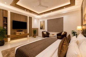 A modern hotel room with a large bed, a flat-screen TV, a seating area, and a large window.
