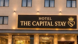 A hotel with a sign reading 'THE CAPITAL STAY' and a crown symbol. - Hotel The Capital Stay (New Delhi)