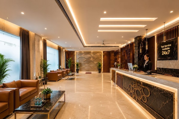 A modern hotel lobby with leather seating, a reception desk, and a large window.