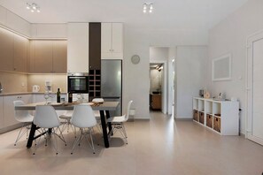 A modern kitchen with a dining area, featuring stainless steel appliances, white cabinetry, and a minimalist design. - Apartment 'La Casa Di Leone - Gio' with Shared Terrace, Wi-Fi and Air Conditioning (Agkisaras)