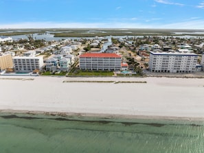 Ein Hotel an der Küste mit einem zentralen Gebäude, einem Pool und Blick auf den Strand.
