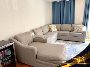 A L-shaped sectional sofa with a side table and a built-in mini-fridge.