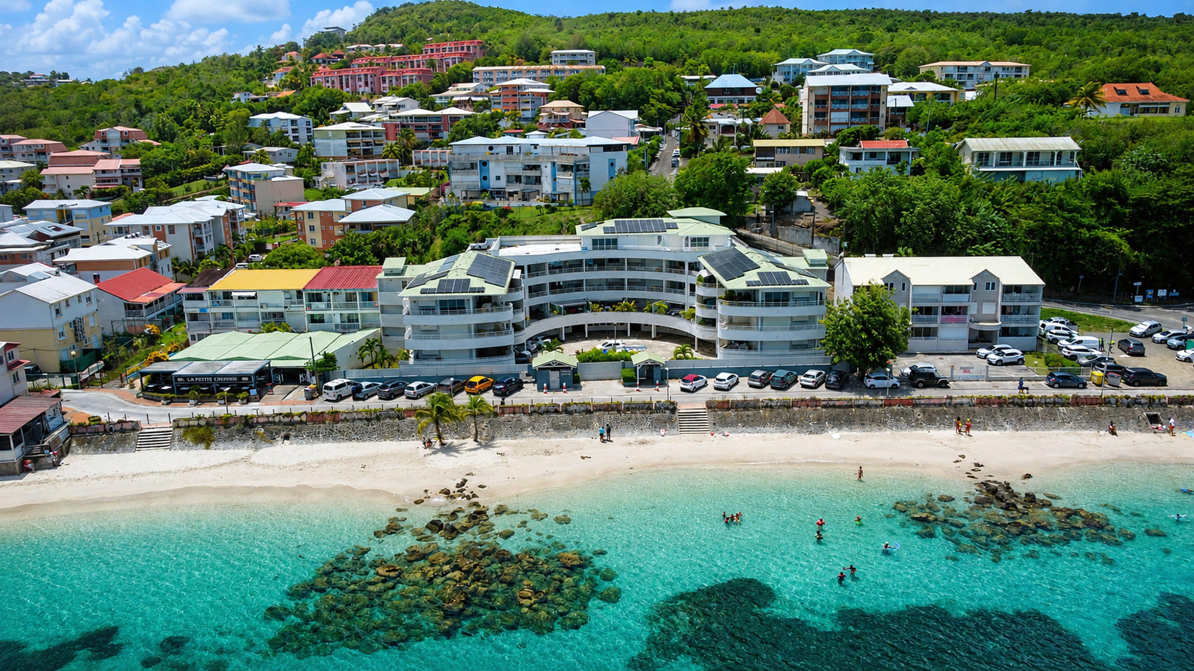 Un hotel frente al mar con varios pisos, estacionamiento y vista a la playa.