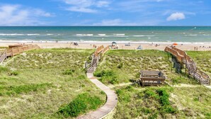 Ein Strand mit Holzstegen, feinem Sand und dem Meer.