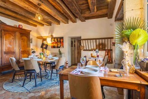 A dining area with a wooden table, chairs, and a rustic ceiling. - Suite La Denise in the Heart of the Vineyards (Curtil-Vergy)