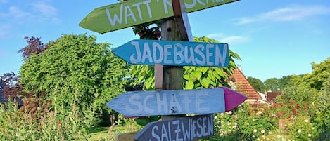 A wooden signpost with directional arrows pointing to various destinations.