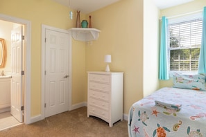 Une chambre à coucher avec un lit, une commode et une porte.