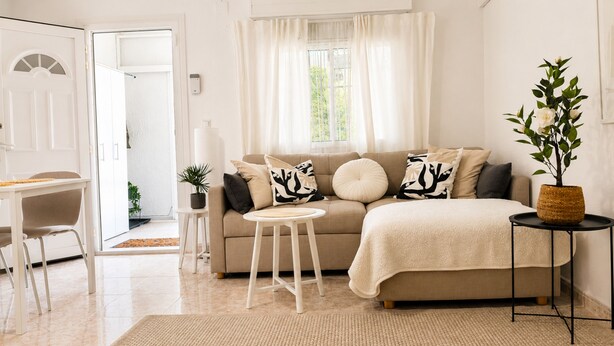 A modern living room with a sofa, a small round table, a chair, and a potted plant. - Your Charming Home in La Siesta (Torrevieja)