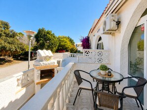 Ein Balkon mit Tisch und Stühlen, einem Grill und einer Zierbrunnen.