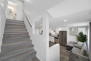 Een modern interieur met een trap, keuken en zithoek.
