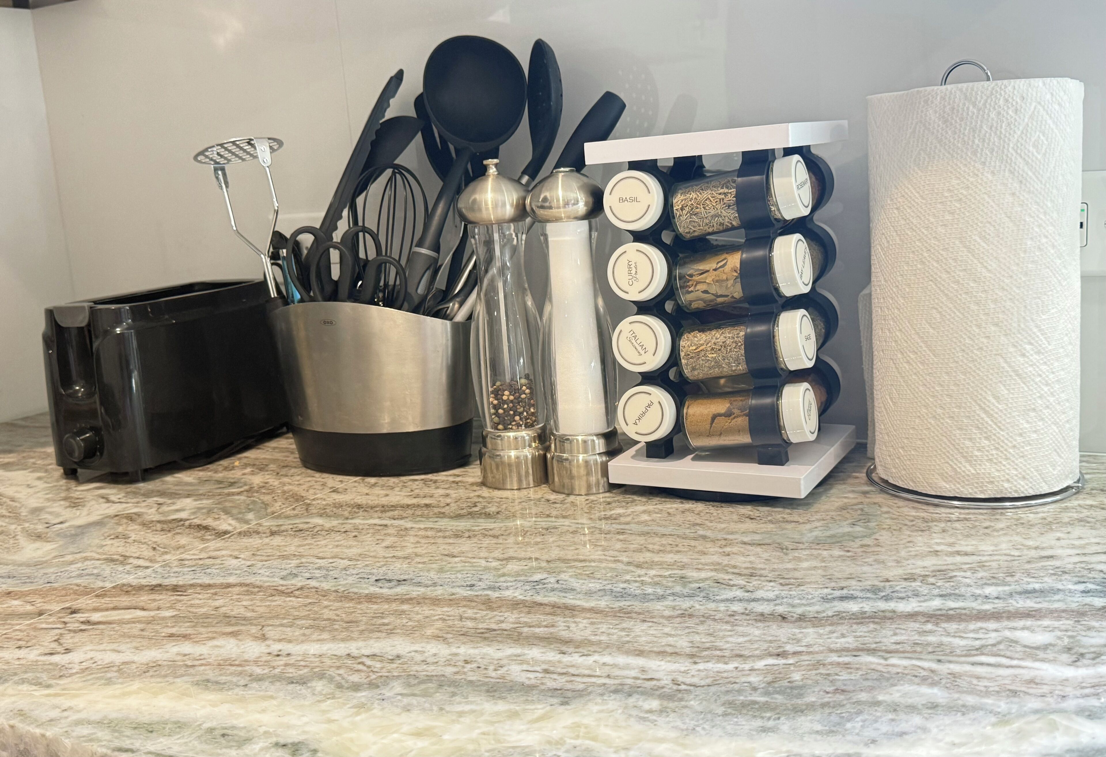 Un plan de travail de cuisine avec un grille-pain, un étagère à épices et un porte-essuie-tout.