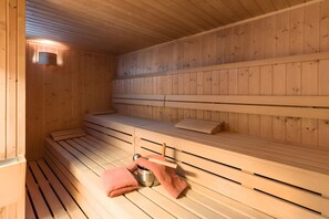 Eine Holzsauna mit Bänken und einem Handtuchhalter.