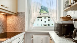 Eine Küche mit Fenster, Toaster, Kaffeemaschine und Heizkörper.