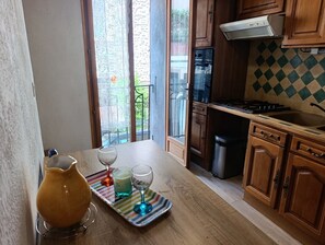 A kitchen with wooden cabinets, a gas stove, and a stainless steel sink. - Small village house in Catalonia: Le Souleillou, beaches 7 mn away (Villelongue-de-la-Salanque)