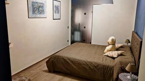 A bedroom with a bed, a nightstand, a lamp, a teddy bear, and two framed pictures on the wall. - B&B La Rocca  (Spoleto)