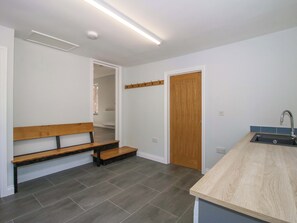 A kitchen with a wooden bench, a sink, and a door leading to another room. - Westington Hall (Leominster)