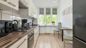 Eine moderne Küche mit einer Holzarbeitsplatte, eingebauten Geräten und einem Fenster mit Fensterläden.