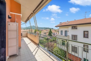 Un balcón con vistas a un pueblo, una puerta y una barandilla.