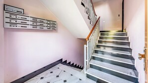 A staircase with a handrail, a marble floor, and a wall-mounted mailbox. - Il Forte - Apartment With Balcony (Sestri Levante)