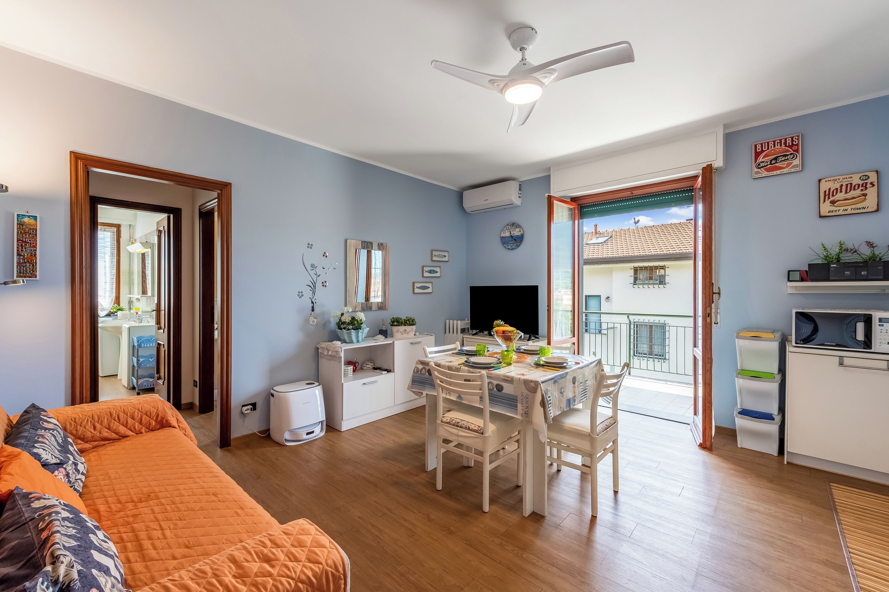 A compact living space with a dining area, a kitchenette, and a balcony.