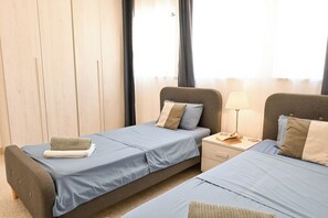 Ein Hotelzimmer mit zwei Betten, einem Nachttisch mit Lampe und einer Holzwand.