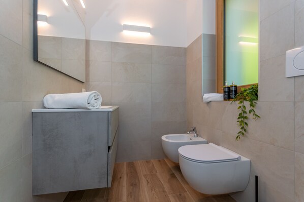 A modern bathroom with a vanity, bidet, and a mirror. - Alpine Haven - Hare Lodge (Cencenighe Agordino)
