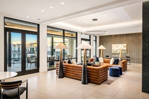 A modern living room with leather sofas, a dining area, and large windows offering a city view. - Maple & Merlot Room | Pool, Laundry, Parking (Dallas)