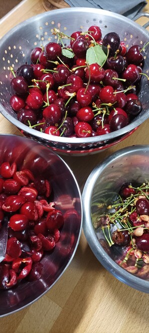Three metal colanders with cherries, one filled with whole cherries, one with halved cherries, and one with cherries and nuts. - Guest Room in Tavaco, Corse-du-Sud – Double Room (Tavaco)