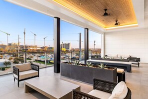 A modern hotel lobby with a large open space, seating areas, and a view of the cityscape. - Obsidian Opulence | Resort Pool, Laundry, Parking (Dallas)