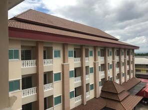 Un hotel de varios pisos con balcones, techo plano y vistas del entorno.