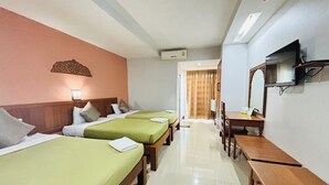 A hotel room with two beds, a desk, a mirror, and a television. - Butnamtong Hotel (Lampang)