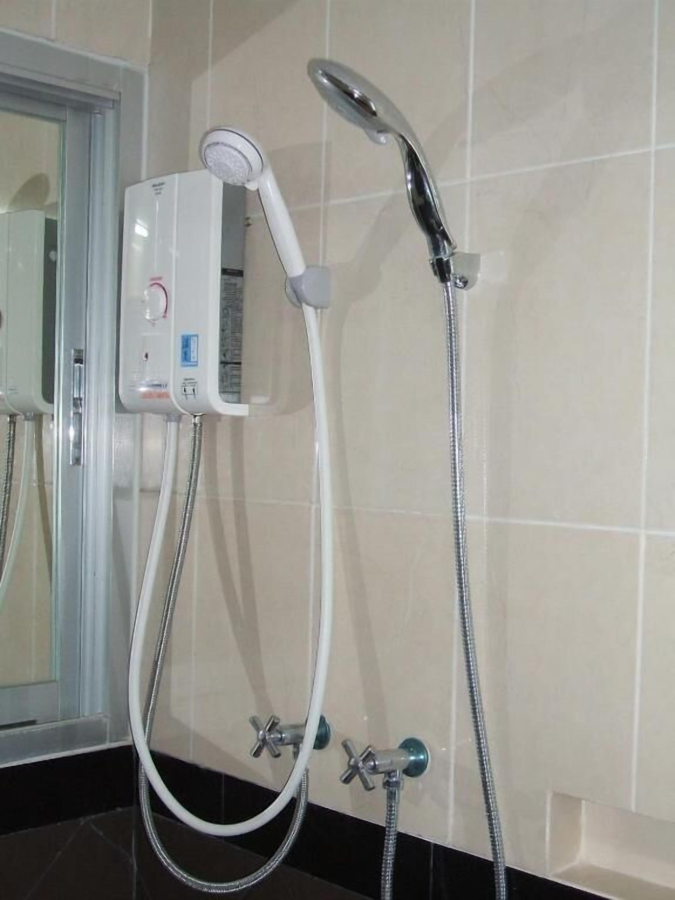 Un baño con cabina de ducha, un cabezal de ducha de mano y un grifo empotrado.