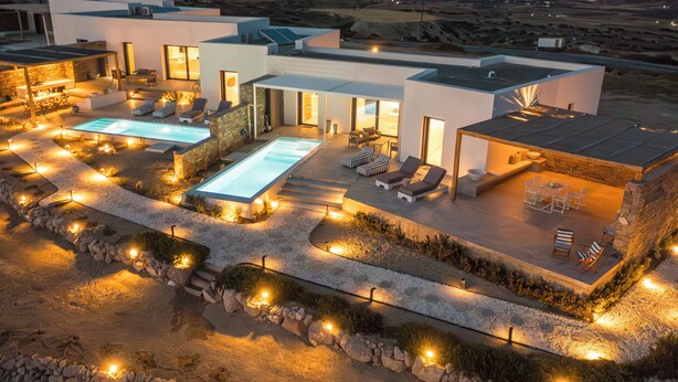 Una casa moderna con piscina, mobiliario exterior y zona de patio.
