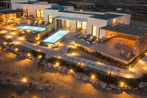 A modern house with a swimming pool, outdoor seating, and a patio area. - Villa Nabia II, Seaview and Sunset view, Private Pool (Adamas)