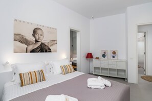 A modern hotel room with a large bed, a bedside table, a red lamp, and a wall-mounted artwork. - Villa Nabia II, Seaview and Sunset view, Private Pool (Adamas)