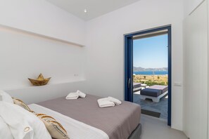 Un dormitorio con cama, toallas, un objeto decorativo y vistas al exterior.