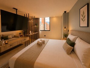 Een moderne hotelkamer met een groot bed, een flatscreen televisie, een houten console en uitzicht over de stad.